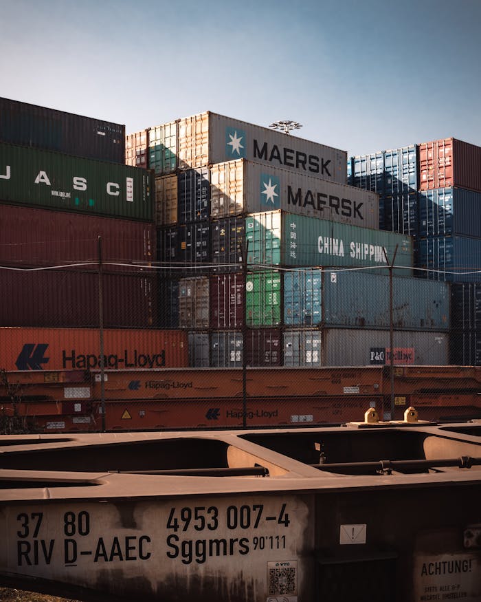 gallery-4 A view of colorful cargo containers stacked at a bustling industrial harbor.