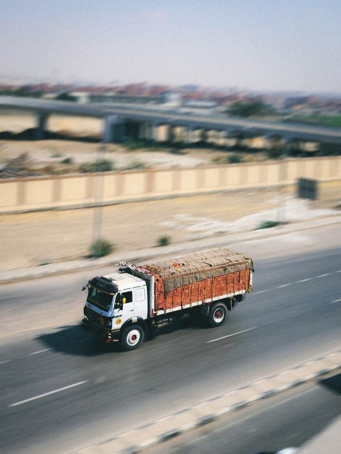 services-02 A cargo truck swiftly travels on a highway, emphasizing logistics and speed.