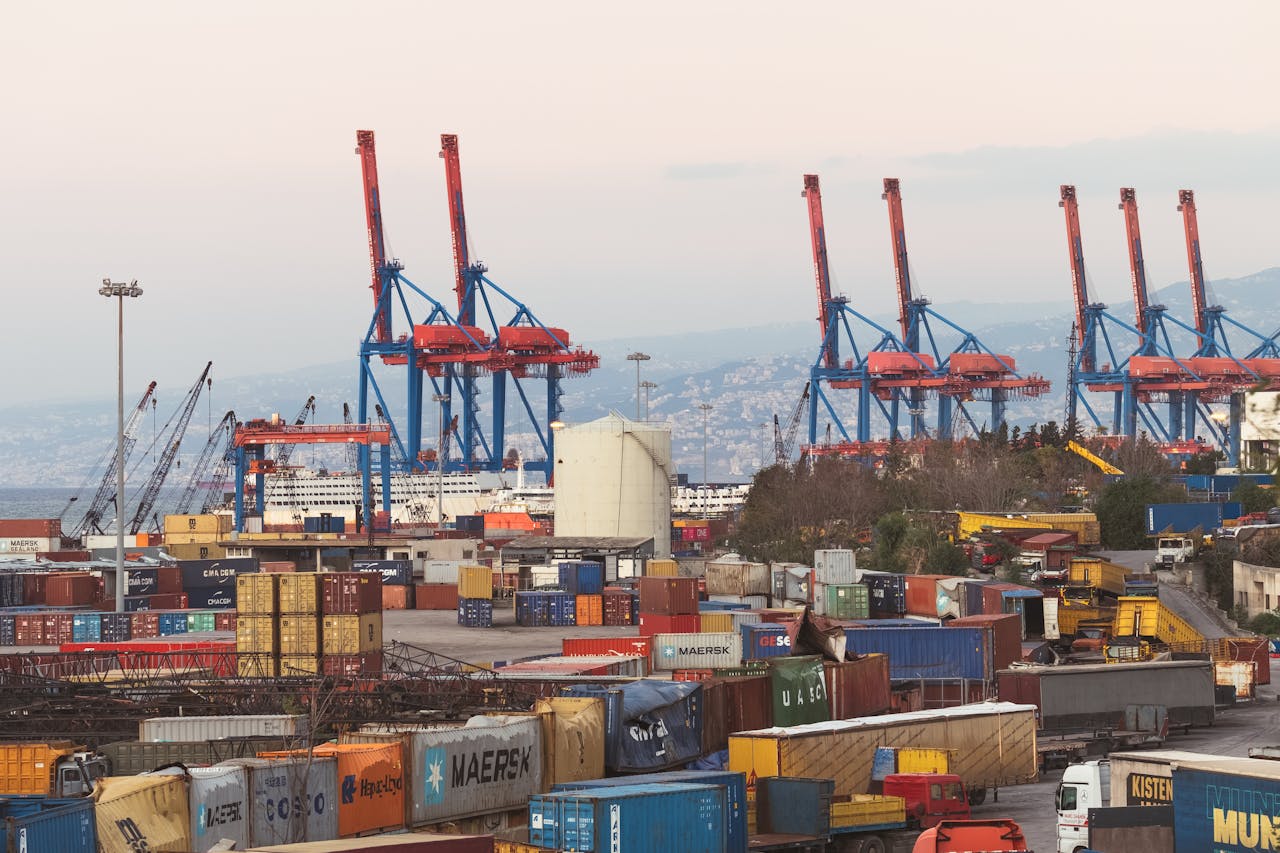 why-choose-us A bustling industrial view of Beirut port with cargo containers and towering cranes.