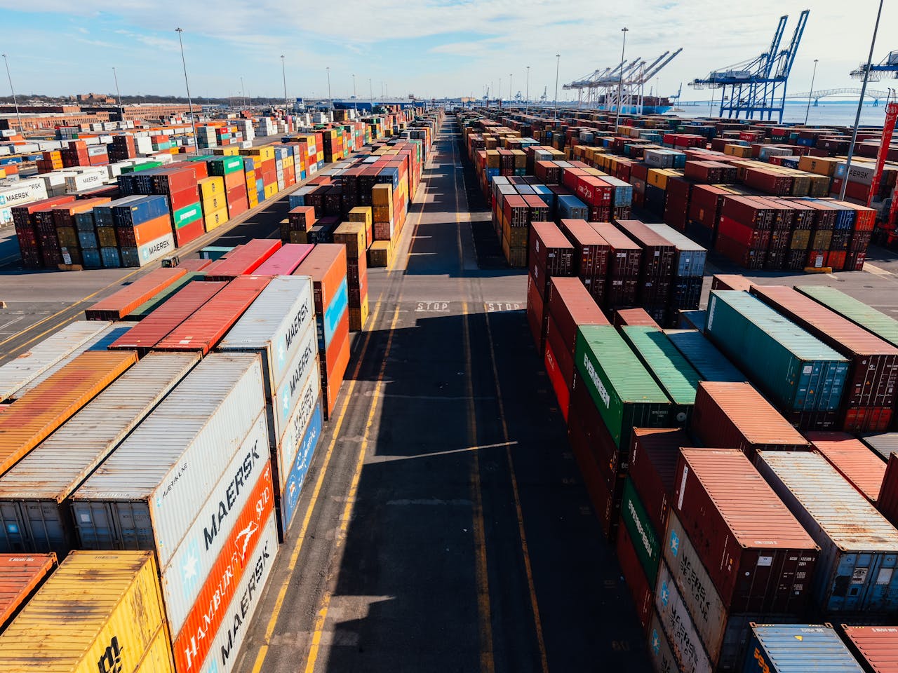 gallery-1 From above of asphalt roadway among large colorful metal containers placed in industrial area under cloudy sky in sunny day